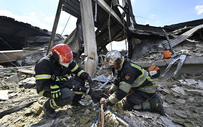 Rescatistas limpian escombros en el centro comercial Amstor en Kremenchuk (28.06.2022).