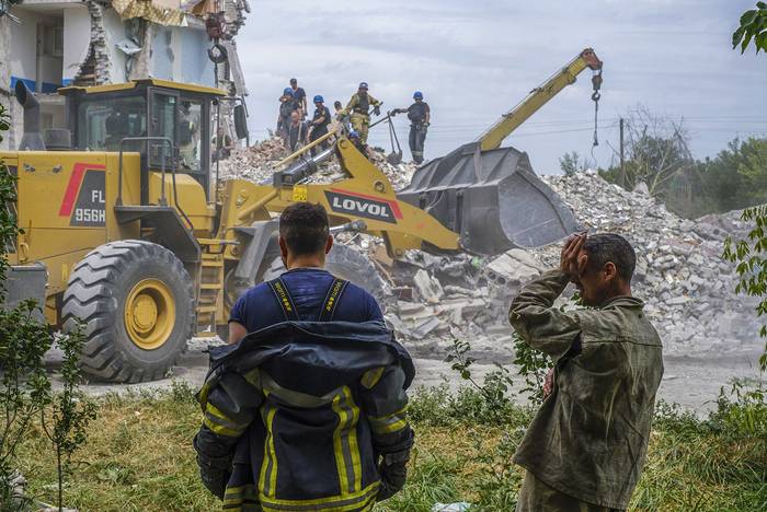 Rescatistas ucranianos en un edificio residencial dañado por un bombardeo, en la ciudad de Chasiv Yar, el 10 de julio, en la región de Donetsk, Ucrania. · Foto: George Ivanchenko, EFE