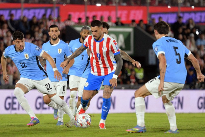 Joaquín Piquerez y Manuel Ugarte, de Uruguay, y el paraguayo Antonio Sanabria, el 5 de junio, en el estadio Defensores del Chaco en Asunción. · Foto: Daniel Duarte, AFP