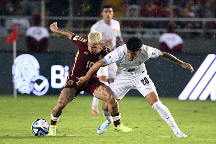 El venezolano Yeferson Soteldo y el uruguayo Maximiliano Araujo, el 10 de setiembre, en el estadio Monumental en Maturín, Venezuela. · Foto: Federico Parra, AFP