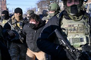 Un hombre es detenido cerca del lugar donde un hombre fue asesinado por agentes federales esa misma mañana en Minneapolis, Minnesota, el 24 de enero. · Foto: Roberto Schmidt, AFP