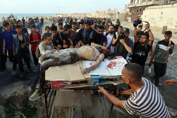 Palestinos transportan el cuerpo de un hombre asesinado mientras esperaba ayuda humanitaria, el 22 de junio, en el oeste de Yabalia. · Foto: Omar Al-Qattaa, AFP