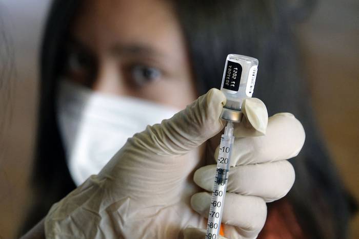 Un trabajador de la salud prepara una dosis de la vacuna Pfizer contra la COVID-19, en una escuela, en Quito (archivo, setiembre de 2021). · Foto: Rodrigo Buendía