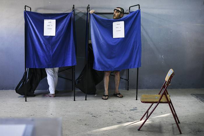 Personas votando en un circuito electoral durante las elecciones generales, el 7 de julio, en Atenas.
 · Foto: Aris Messinis, AFP