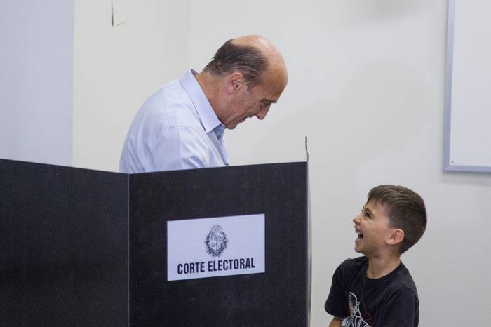 Votación del candidato del Frente Amplio, Daniel Martínez, junto a uno de sus nietos. · Foto: .