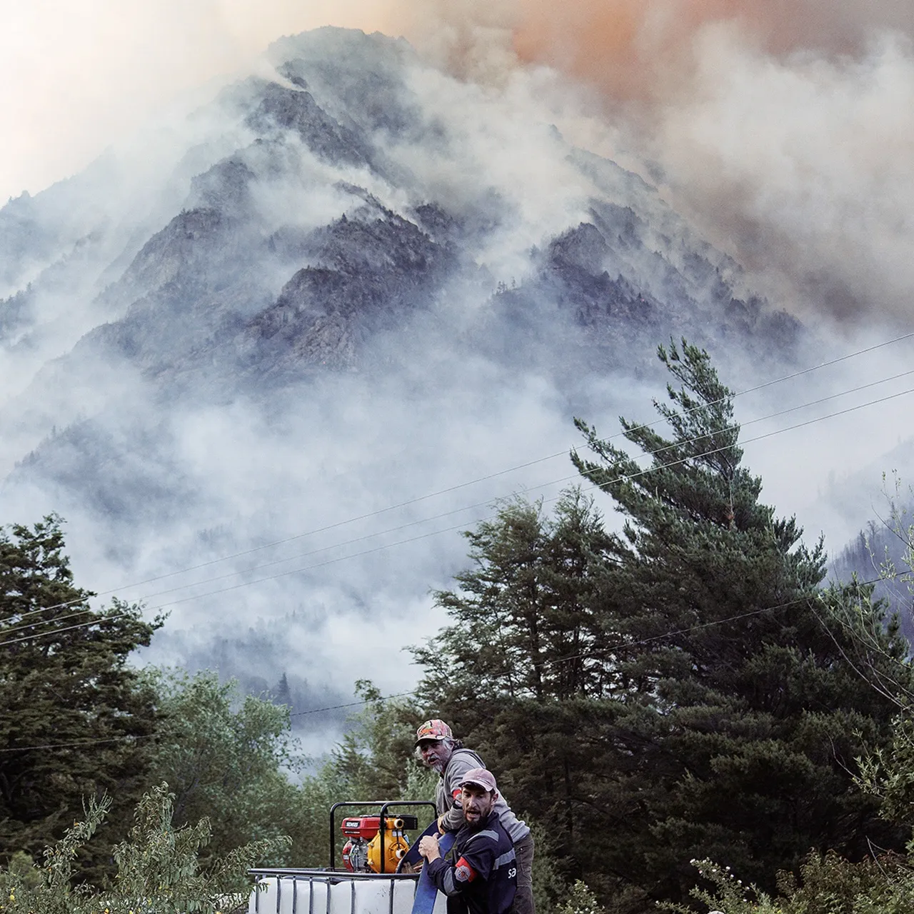 Integrantes de la Brigada Patagónica cargan agua para combatir un incendio en el cerro Pirque. · Foto: Denali Degraf